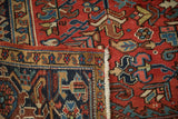 The secured side selvage and hand-knotted foundation visible on a vintage Persian Heriz corner.