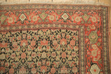 Close-up of the intricate Herati pattern and geometric borders on an antique Persian Senneh rug.