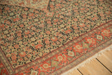 The low-worn pile and detailed Herati motif of an antique Persian Senneh rug in fuchsia and charcoal.