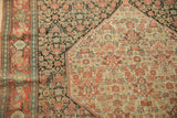 Worn knot heads on the charcoal Herati field and ivory medallion of an antique Senneh rug.