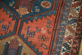 Close-up of stylized animal figures and a serrated leaf main border on a vintage Kurdish Hamadan rug.