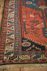 Serrated leaf main border on a vintage Kurdish runner in brick red, dusty teal, and navy blue.