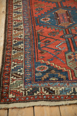 Intricate serrated leaf border on a vintage Kurdish rug in red, blue, and ivory.
