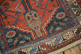 Corner detail of a vintage Kurdish rug showing its serrated leaf border and time-softened wear.
