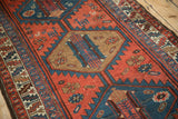 The hand-knotted texture and serrated geometric patterns of a vintage Kurdish runner.