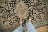 Close view of the distressed texture and geometric bird motifs on a vintage Hamadan rug.