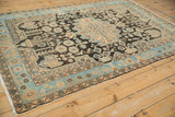Corner of a distressed Persian Hamadan rug showing its sky blue border and low-pile texture.