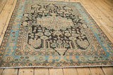 Angled view of a vintage Hamadan rug's geometric pattern, with stylized birds and a sky blue border.