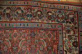 Corner of vintage Bijar carpet, pale beige border with plant motif and red Herati field.