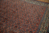 Vintage Persian Bijar carpet: brick red Herati field, dusty blue accents, and a pale beige scrolling leaf border.