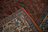 Vintage Bijar carpet's pale beige germinating plant border contrasting with brick red Herati field.