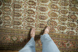Distressed vintage Hamadan rug with dusty terracotta, gold, brown boteh field and meandering border.