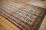 Vintage Malayer rug corner displaying ivory Herati field, multi-hued traditional borders, and fringe.