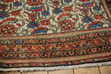 Vintage Malayer rug border detail with stylized geometric patterns, ivory fringe, and Herati motif.