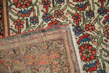 Vintage Malayer rug's folded corner showing detailed red, blue Herati design and the intricate woven foundation.