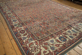 Angled perspective on a distressed Mahal carpet's Herati field and oversized floral border.