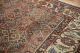 Evenly worn Herati motifs in the field meeting the wide ivory border of a Persian Mahal.