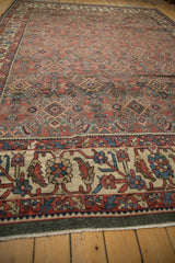 Low-angle perspective of a vintage Mahal carpet, showing its full length and wide, oversized Herati border.