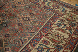 Close-up of a distressed Mahal carpet's silver field and contrasting ivory border with Herati motifs.