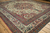 A corner view of a fine antique Kerman showing the intricate floral border and ivory arabesque field.