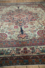 A detailed perspective on the intricate floral patterns and scrolling vines of an antique Kerman carpet.
