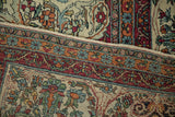Intact side cord selvage and finely woven floral border on an antique Persian Kerman carpet.
