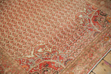 Angled detail of a Malayer rug's pomegranate corner spandrel with tangerine orange shades.