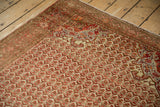 Tangerine orange pomegranate spandrel on a distressed vintage Persian Malayer rug.