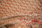 Folded vintage Malayer rug revealing the distressed pile, blossom field, and pomegranate border.