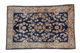 Vintage Sarouk rug with floral sprays on a cobalt blue ground and a contrasting pale rose border.
