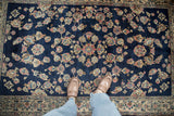 A close view of the vintage Sarouk rug's lustrous wool pile and floral sprays in rose and ivory.