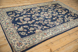 Angled perspective on a vintage Sarouk rug's lustrous floral pile and detailed ivory border.
