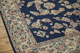Corner detail showing the Sarouk rug's platinum rose border and floral blue field.