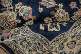 A vintage Sarouk rug folded to show the deep cobalt blue field against the pale rose border.