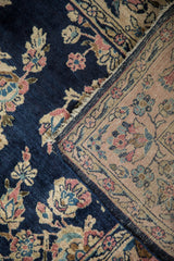 Hand-knotted back with a platinum rose ground against the rug's deep blue floral pile.