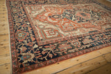 Antique Serapi carpet's wide navy border with interconnected floral vines and soft blush palette.