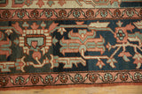 Antique Serapi carpet's wide border with curvilinear floral vines in navy, dusty blush, and seafoam.