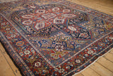 Vintage Heriz carpet detail showing intricate floral palmettes and Herati motifs in deep jewel tones.