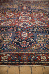 Vintage Heriz carpet's red and navy border, intricate Turtle Samovar motif, and white fringe.