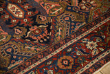 Detail view of the Heriz rug's deep cherry red and navy blue main border with intricate Samovar motifs.