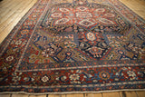 Cherry red border and geometric field details of the Vintage Heriz carpet.