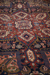 Vintage Heriz rug detail showing rich cherry red and navy blue geometric and floral motifs.