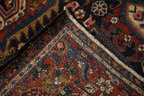Vintage Heriz hand-knotted carpet detail: intricate back, fringe, and cherry red Herati motif.