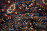 Vintage Heriz carpet's unique deep navy, cherry, and gold Herati patterns on folded pile.