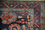 Meandering vine main border detail in madder red and sapphire blue on a vintage Lilihan carpet.