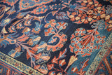 Scrolling vines and arabesques in red and blush on the dense sapphire blue pile of a Lilihan carpet.