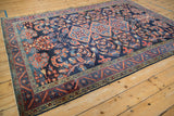 Angled view of the Lilihan carpet's vine border and arabesques against a rich, sapphire blue field.