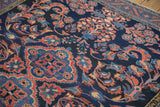 Angled view of the vintage Lilihan carpet's scrolling vines and floral arabesques.