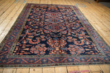 Full perspective of a vintage Lilihan carpet with a sapphire blue field and red arabesques.