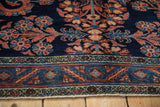 Fine Lilihan carpet's meandering vine border and scrolling floral pattern on a sapphire blue field.